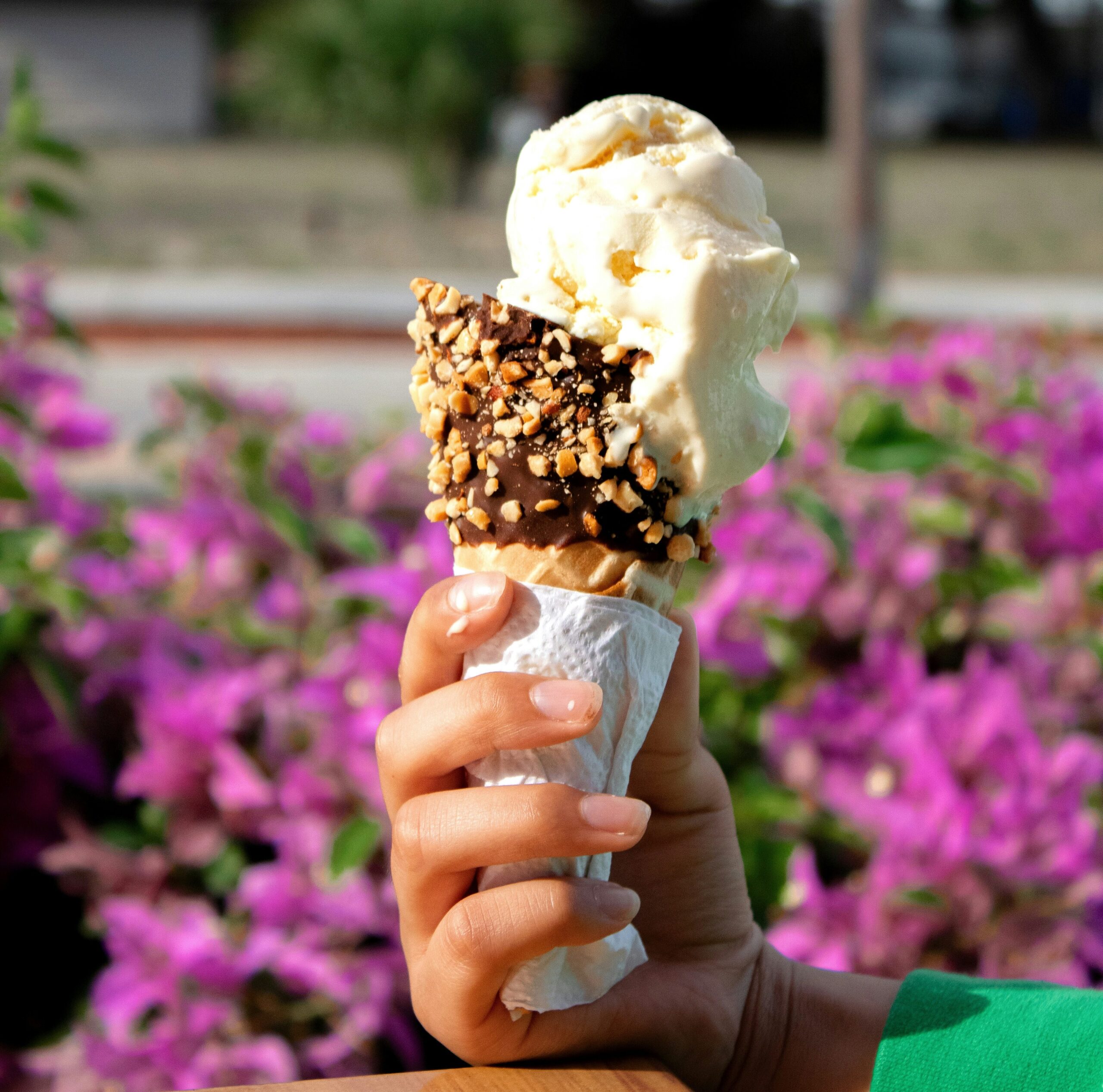 fotografía de un helado de vainilla con un cono de chocolate y virutas de nueces.