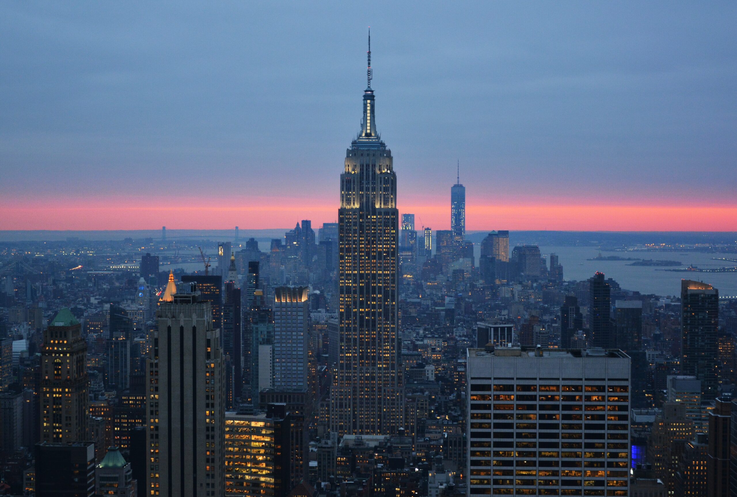 Vistas de la ciudad de Nueva York durante el atarceder con un cielo rosa y oscuro.